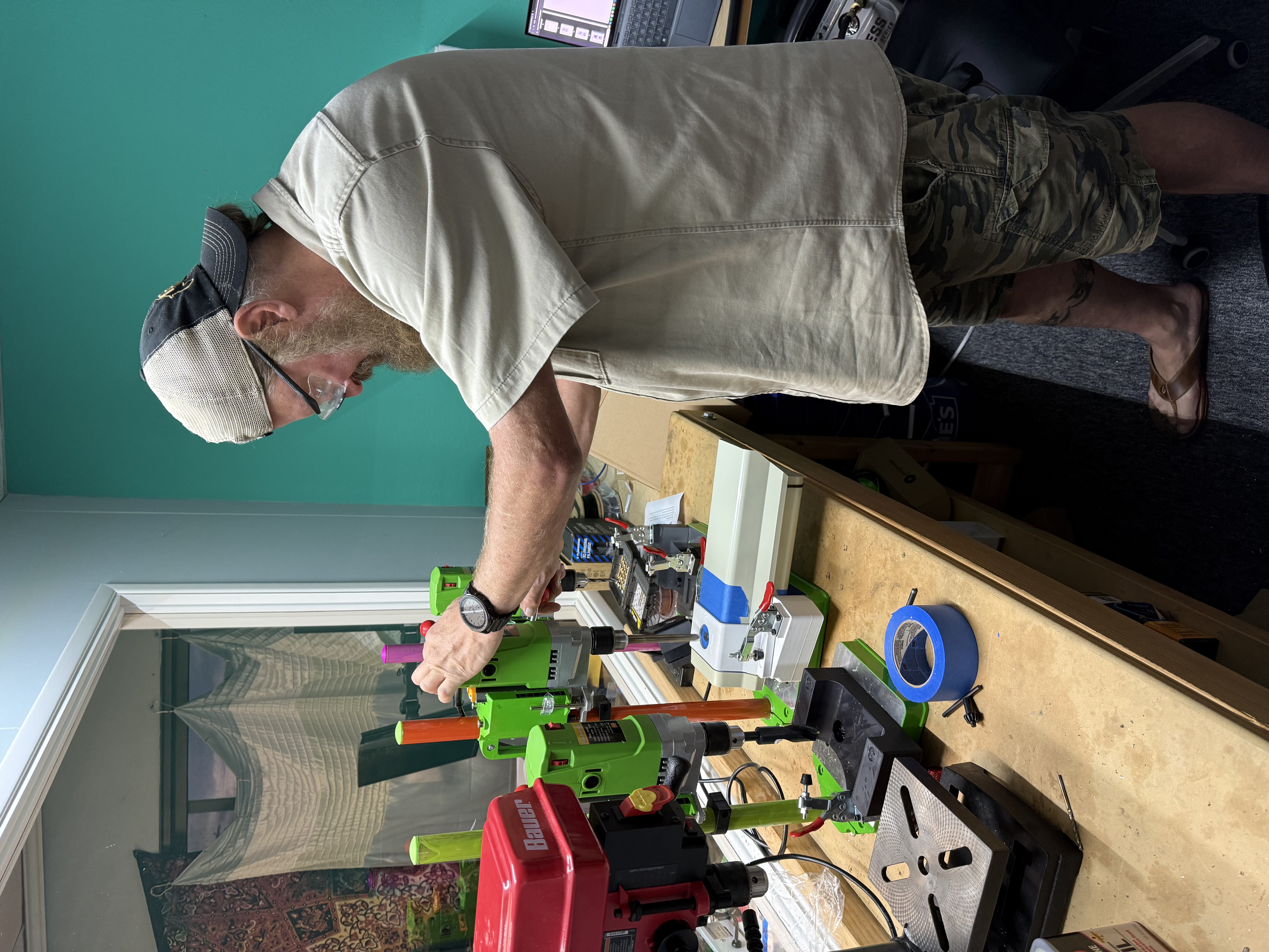 Iron Hornet machinist at the drill press, fixturing an Iron Eyes enclosure plate.