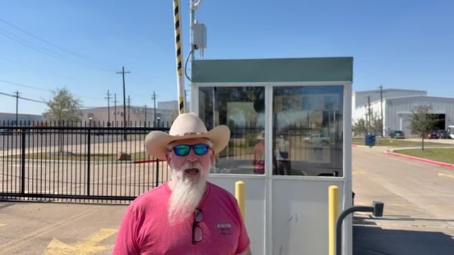 Iron Hornet customer on-site in Texas, standing in front of an Iron Eyes guard kiosk with a gate arm overhead.