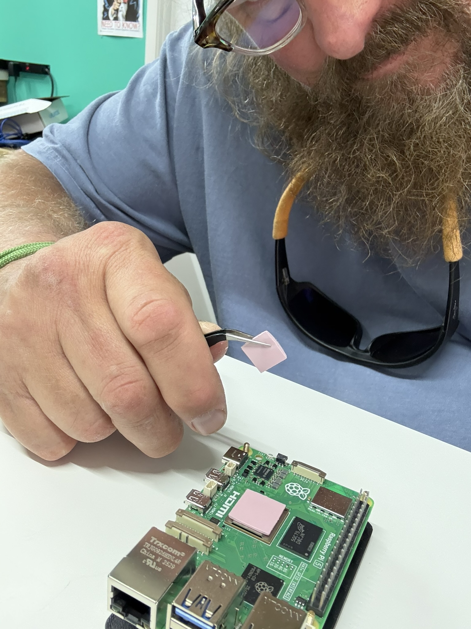 An Iron Hornet engineer applying a thermal pad to a Raspberry Pi 5 on the workbench.